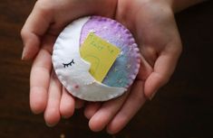 a child's hand holding an ornament shaped like a half - moon