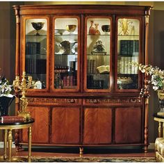 a wooden china cabinet with glass doors and shelves