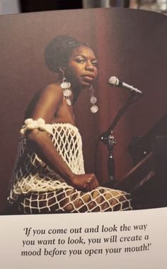 an image of a woman sitting in front of a microphone with a quote on it