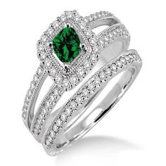 a green diamond ring set on top of a white gold band with diamonds around it