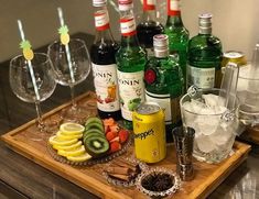 a wooden tray topped with lots of bottles and glasses