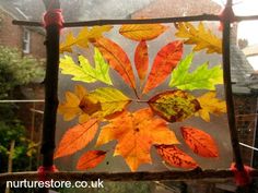 an autumn leaf art project is displayed in the window