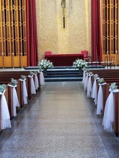 an empty church with pews and flowers on the sidelines in front of it