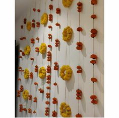 the wall is decorated with yellow flowers and orange candies hanging from it's sides