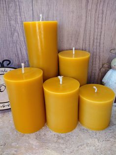 four yellow candles sitting next to each other