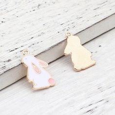 "Adorable little white enameled bunny Approx:22mm x14mm( 7/8\" x 4/8\") Hole size: 1.7mm( 1/8\") Thickness: 1.5mm Quantity: pick at checkout Metal alloy with gold toned backs Have questions? or are you looking for something similar that you want me to carry? please let me know. HOW PACKAGES ARE SHIPPED AND UPGRADED SHIPPING OPTIONS: If you don't see the option or province you need, please contact me before purchasing so I can update a listing for you PACKAGES SHIPPED WITHIN CANADA: Mail in Canad White Enamel Pendant Charm Necklaces, Cute White Charms For Gifts, White Enamel Charm Necklaces, Rabbit Pendant, Metal Charms, Pink Bunny, You Want Me, Mail Letters, Metal Charm