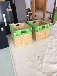 two boxes sitting on top of a table covered in white paper next to each other