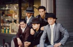 four men in suits and hats are posing for a photo on the steps outside a store