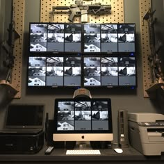 a computer monitor sitting on top of a desk in front of a wall mounted clock