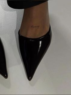 a woman's foot with the word love tattooed on her lower leg and ankle