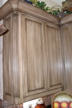 the cabinets in this kitchen are made of wood and have decorative glass vases on them