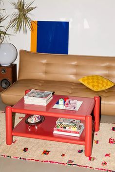 a red coffee table sitting in front of a brown couch