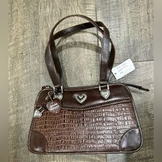 New With Tags Vintage Brighton Look Alike Handbag Purse Brown Genuine Leather Beautiful Silk Pattern Inside With 2 Pockets Silver Hearts On Front And Heart Zipper Pocket On Back *Please Note This Is Not A Brighton Brand Bag, It Is A Look Alike* Approximately 11” Wide And 7” Tall * Please See Photos For Condition - This Bag Is New With Tags But It Is Vintage & It Has Been In Storage For Several Years And Has A Small Spot On Back Left Corner That Shows A Scuff Mark (Last Photo)* Brighton Purses, Silk Pattern, Messenger Purse, Brighton Bags, Maroon Leather, Shoulder Strap Bag, Brown Shoulder Bag, Brown Leather Strap, Large Shoulder Bags