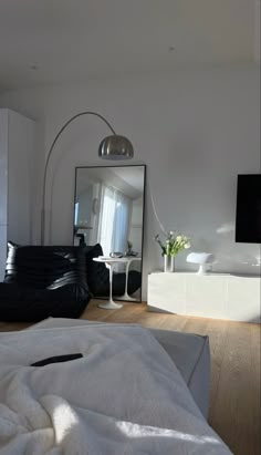 a living room with white furniture and a large mirror