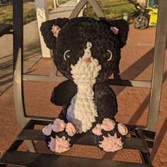 a black and white teddy bear sitting on a chair