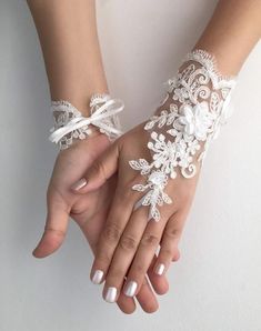 two hands with white lace and flowers on them