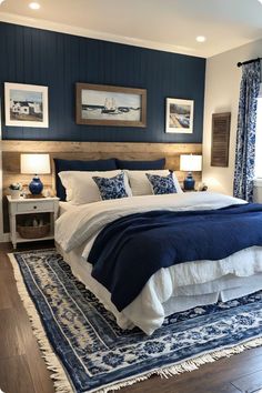 a bedroom with blue and white decor on the walls, wood flooring and bedding