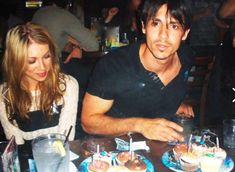 two people sitting at a table with cupcakes