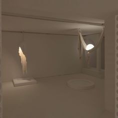 an empty room with two suspended lights on the ceiling and one light in the corner