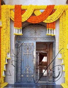 an entrance to a building decorated with flowers and garlands on the door, surrounded by yellow curtains