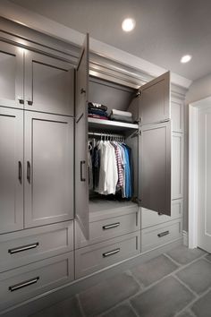 an open closet with clothes on hangers and shirts hanging from the doors in it