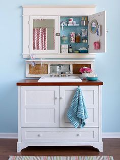 a bathroom with blue walls and white cabinetry on the counter top, along with a striped rug