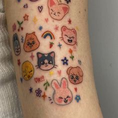 a woman's arm with many stickers on it, including cats and kittens