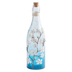 a blue glass bottle with flowers painted on it's side and a corked top