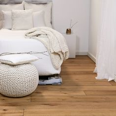 a white bed sitting on top of a wooden floor