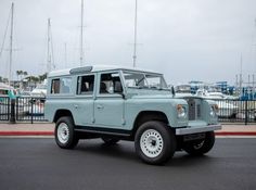 a light blue jeep is parked on the street