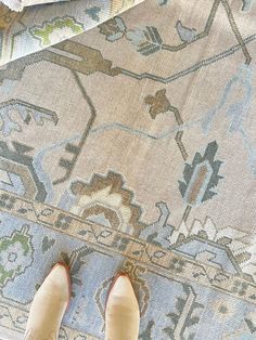 a person standing on top of a rug with their feet propped up against the carpet