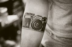 a man with a camera tattoo on his arm