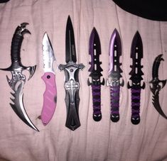 five different types of knives are lined up on a bed with pink and purple accents