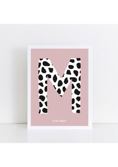 the letter m is made up of black and white spots on a pink background with an animal print