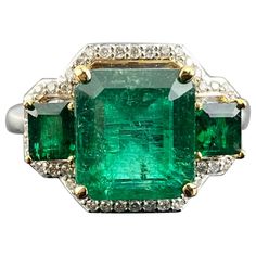 A unique three stone cocktail ring, with 4.31 carat natural Zambian Emerald and 0.76 carat natural Zambian Emerald side stones, with 0.23 carat White Diamond halo all set in solid 18K White Gold. The Emeralds are transparent and have a beautiful vivid green color, and amazing shine/luster. The ring is currently sized at US 7, can be resized. We provide free shipping, and accept returns! Please feel free to message us for more information. Vintage Style Rings, Halo Style, Rings Fashion, Zambian Emerald, Three Stone Rings, Zambia, Diamond Halo, Emerald Diamond, Emerald Ring