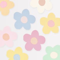 colorful paper flowers on a white background with pink, blue, yellow and green centers