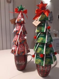 two christmas trees made out of wine bottles with candy wrapped in ribbon and bows on them