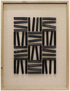 an art piece made out of black sticks in a wooden frame with a white background