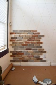 a room that has some paint on the walls and is being painted white with brown bricks