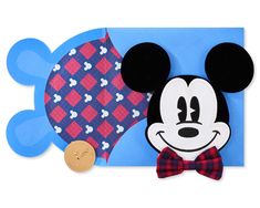 a mickey mouse cut out with a bow tie on it's head next to a paper fish