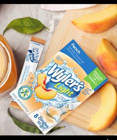 a box of juice next to sliced peaches on a cutting board