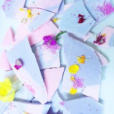 several pieces of pink and yellow soap with flowers on them, all over the place