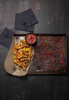 a plate with french fries and ketchup on it next to some napkins