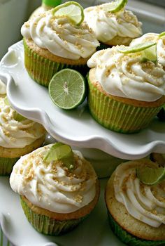 lime cupcakes with white frosting and lime wedges on a platter