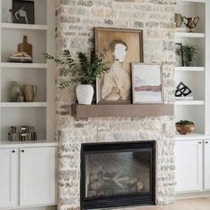 a living room filled with furniture and a fire place under a painting on a brick wall