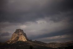 a mountain with dark clouds in the background