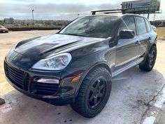 a black porsche cayen is parked in a parking lot