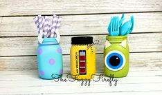 three mason jars with toothbrushes and eyeballs on them