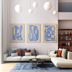 a living room with three paintings on the wall