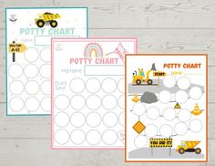 three printable potty chart cards with construction trucks and rainbow in the background on a wooden table